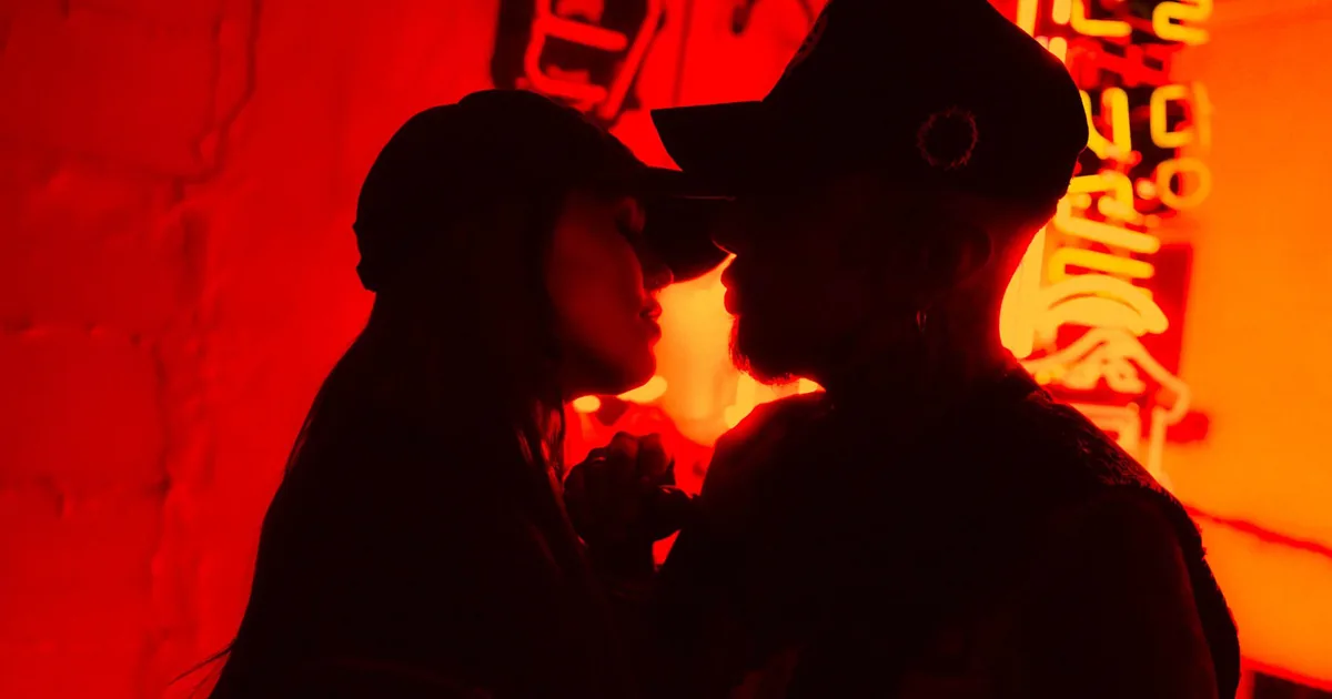A couple in silhouette against red neon light on a couples photoshoot in Tokyo
